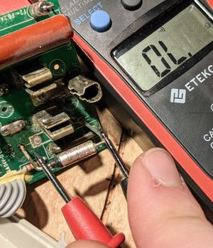 Multimeter checking the current across the fuse, showing that the fuse is blown